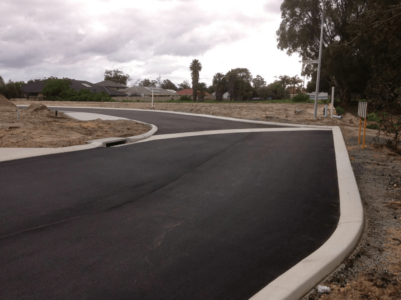 two men in hi vis next to cement mixer laying asphalt driveway